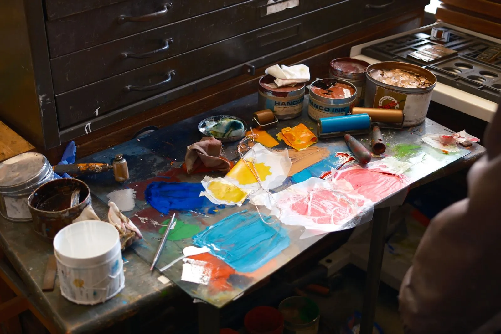 Vibrant collection of paints and tools on an artist's workbench, ready for creativity.